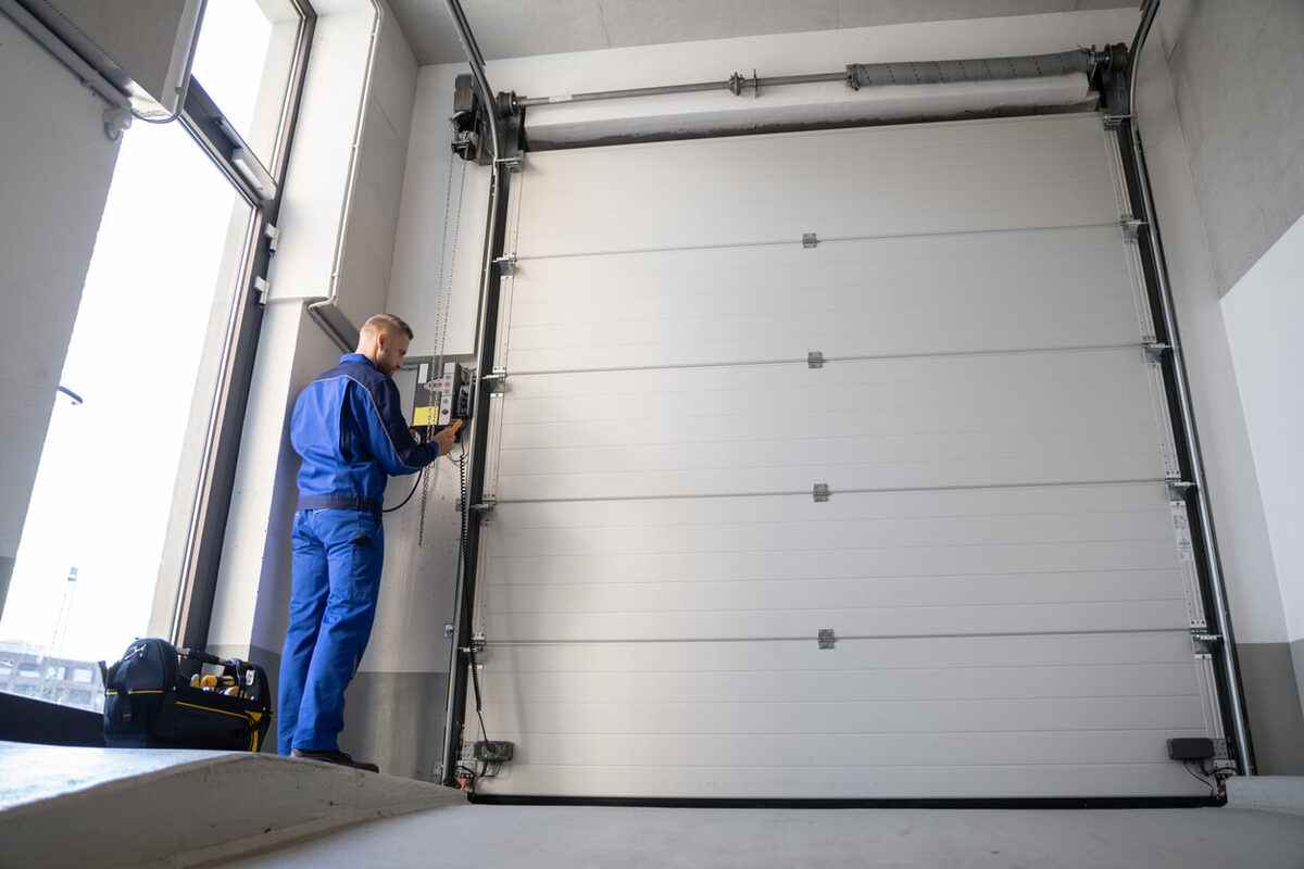 A G Brothers technician beside a residential garage door and opener unit