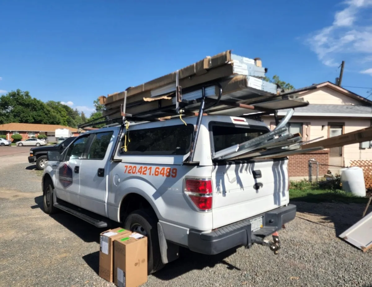 A G Brothers Garage Doors work truck loaded with new garage door panels and track at a Denver-area job